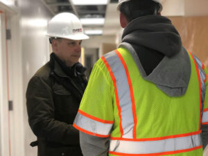 Two PAINTech contractors talking How Commercial Concrete Floor Polishing Reduces Monthly Utility Bills