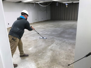 Man washing a commercial floor Why Working with Commercial Flooring Contractors Will Help Your Budget