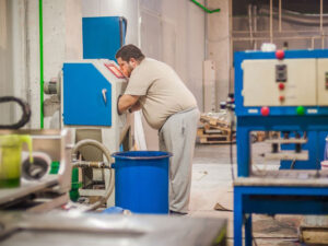Worker sandblasting a cabinet Sandblasting Cabinets: When and Why You Should Call a Pro