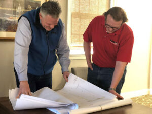 Two men looking at blueprints Why Small Window Treatments Are Worth It