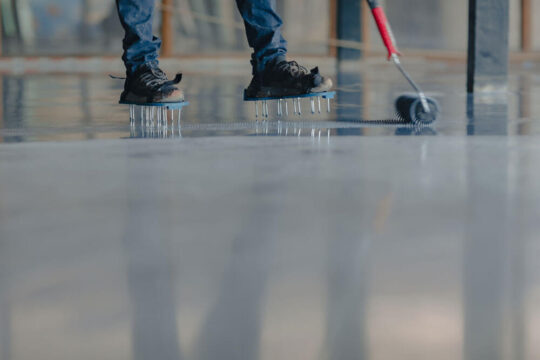 Man applying an epoxy coating to a garage floor