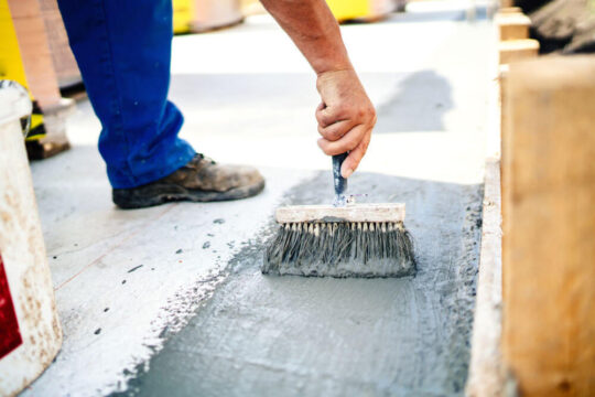 Man concrete waterproofing the floor