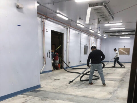 Workers applying epoxy floor coating to a floor.